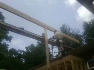 Carpenter setting a ridge beam over a new addition frame — Ice Dam Removal by Roofing Brothers in Cambria
