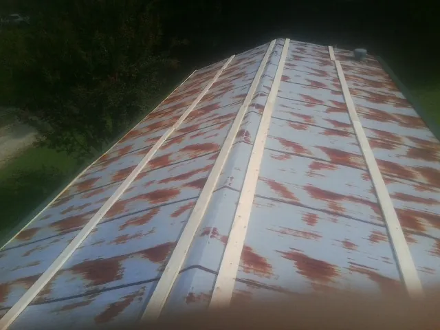 Rusted metal roof panels with new wood purlins before replacement — Storm Damage Roof Repair in Cambria by Roofing Brothers