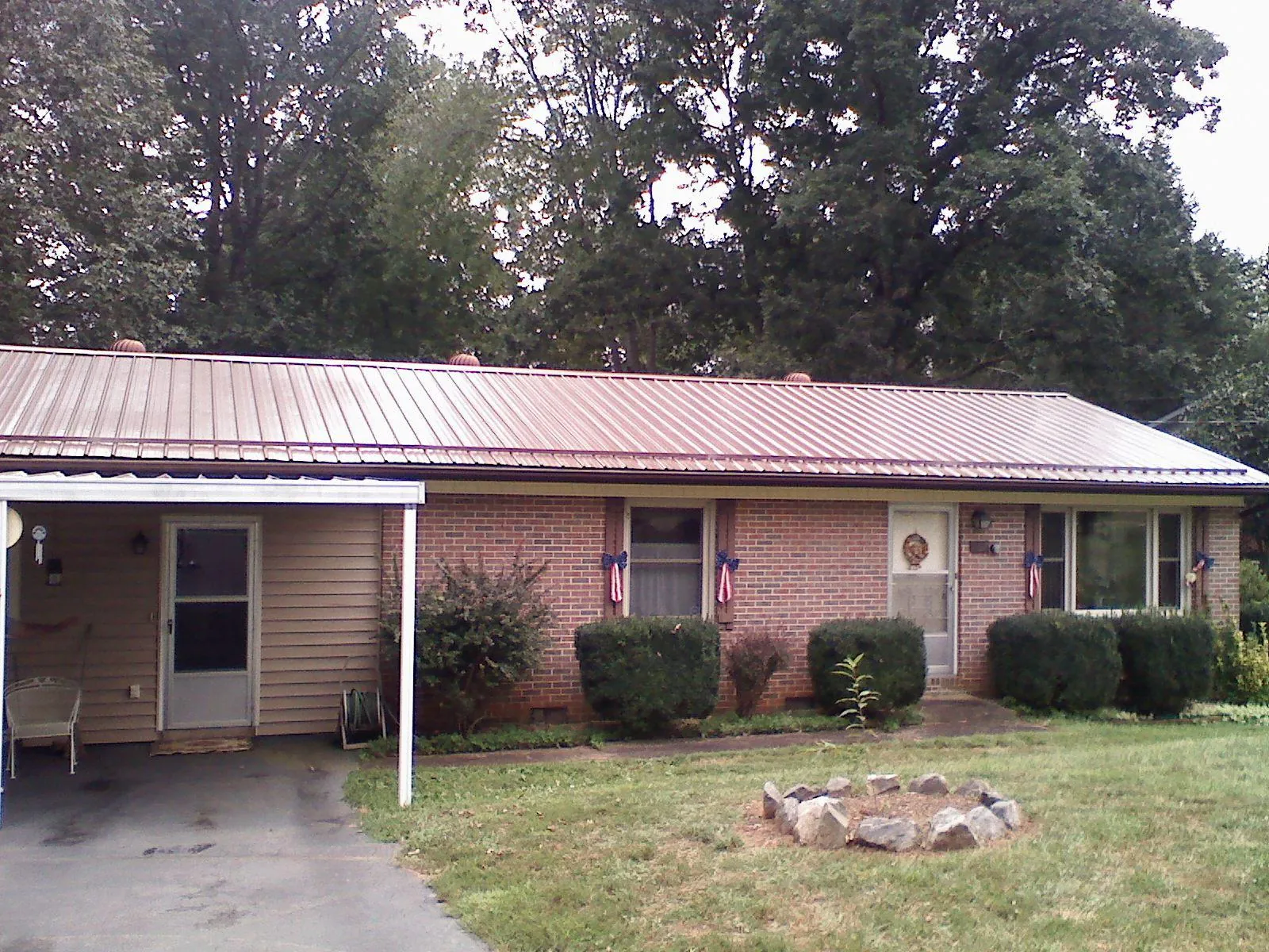Bronze metal roof and carport on a brick ranch home — Roof Repair work by our crew in Cambria