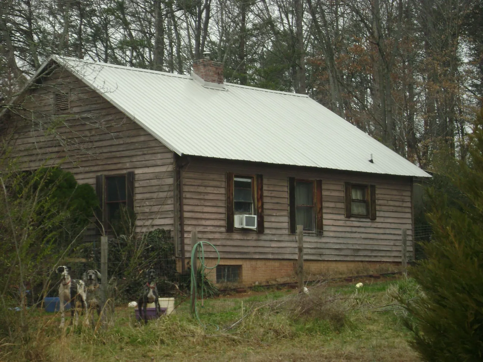 White metal roof on an old wood sided farmhouse, from a Metal Roof Installation job in Cambria